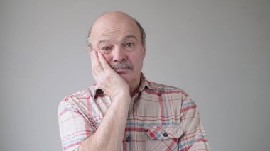 Sıkıcı, yaşlı, İspanyol bir adamın yanağında el ele tutuşması kasvetli ve hüzünlü bir ifade. Zaman tükeniyor, çok yorgunum. Stüdyo çekimi