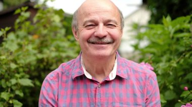 Parkta açık havada mutlu gülümseme yaşlı adam. Pozitif yüz insan duygu