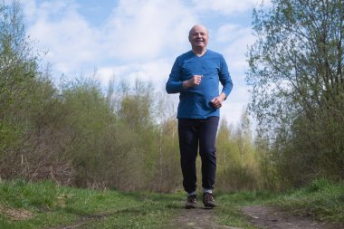 Aktif kıdemli adam koşuyor. Sağlıklı emeklilik yaşam tarzı.