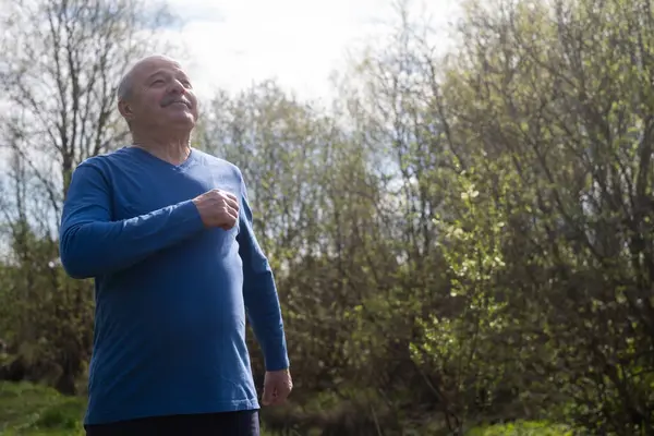 Active senior man is jogging breathing fresh air. Healthy retirement lifestyle.