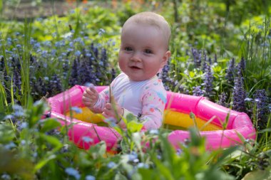 Bebek sıcak bir yaz gününde bahçede köpük banyosunda oturuyor. Açık hava su tedavileri.
