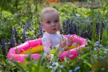 Bebek sıcak bir yaz gününde bahçede köpük banyosunda oturuyor. Açık hava su tedavileri.