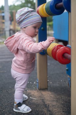 Kafkasyalı bebek oyun alanında renkli yüzüklerle oynuyor..