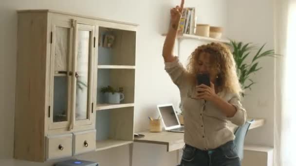 在智能手机听音乐时 有魅力的卷发女子在跳舞 — 图库视频影像