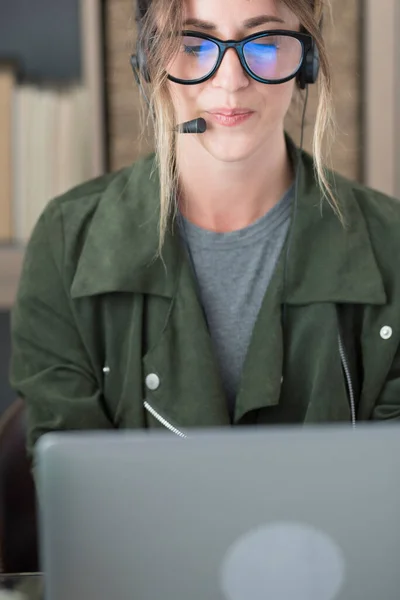 Ung Affärskvinna Med Glasögon Och Headset När Använder Laptop Arbetsplatsen — Stockfoto