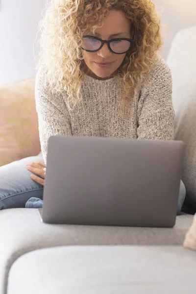 Kıvırcık Saçlı Gözlüklü Güzel Bir Kadın Evde Dizüstü Bilgisayar Kullanırken — Stok fotoğraf
