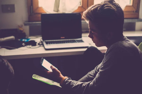 Sosyal Medya Için Akıllı Telefon Odada Dizüstü Bilgisayarın Yanında Otururken — Stok fotoğraf