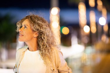 Gece vakti aydınlık şehir caddesinde dikilen genç ve güzel bir kadına yaklaş.. 