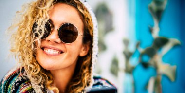 Yuvarlak güneş gözlüğü takan mutlu, genç kadın portresi