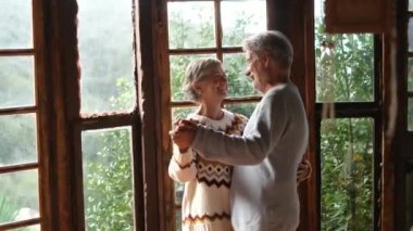 Elderly people happy lifesryle activity with senior man and woman dancing excited at home for love and relationship