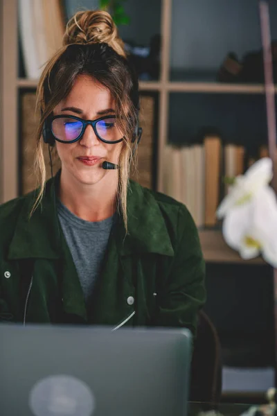 Ung Affärskvinna Med Glasögon Och Headset När Använder Laptop Arbetsplatsen — Stockfoto