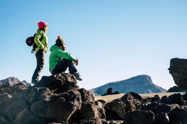 Birkaç kadın doğa yürüyüşü sırasında dinlenme molası veriyor. Arka planda dağ ve çöl var. İnsan kavramı ve seyahat macera yaşam tarzı