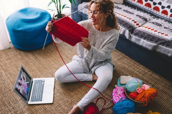 stock image Modern woman do knit work at home thanks to video tutorial online content on laptop computer and wireless connection. 