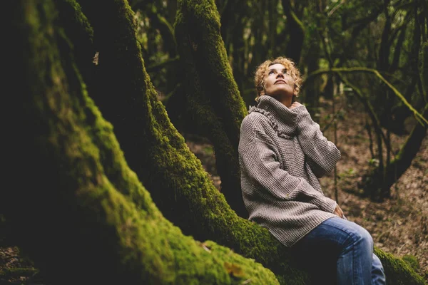 在热带美丽的森林里 一位成年女子坐在一只长着绿色麝香的树干上 享受着放松与自然的联系 — 图库照片