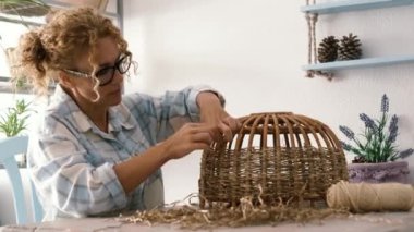 Creative handwork at home in indoor hobby leisure activity for woman realizing wicker lamp or basket on the table