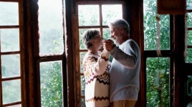 Elderly people happy lifesryle activity with senior man and woman dancing excited at home for love and relationship