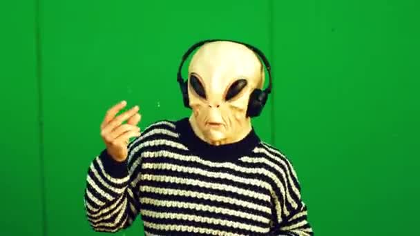 Person Alien Mask Headphones Posing Green Wall Pointing Fingers — Stock videók