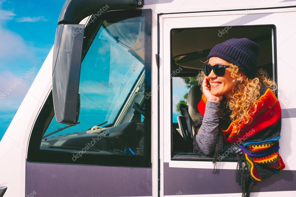 Cheerful and happy adult pretty woman outside the window of her camper van motorhome enjoy alternative travel and free nomadic lifestyle. Vanlife and tourist female people