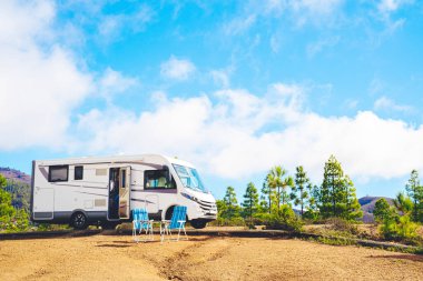 Doğadaki güzel turizm karavanı kamp alanı. Seyahat ve karavan kiralama tatili. Modern karavanın mavi gökyüzü arka planına park edilmiş Vanlife ve Gezinti Konsepti
