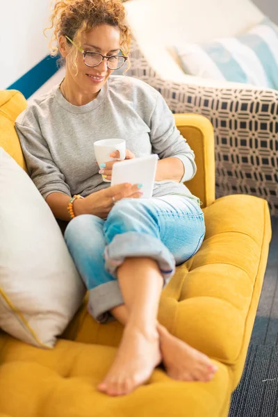Confident Caucasian Adult Woman Sitting Sofa Reading Book Using Electronic — Stock Photo, Image