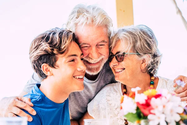 Happy family with grandparents and grandson together laughing and having fun. Cheerful senior and young people hugging with love. Friendship with mixed generations. Happy people enjoying and smiling