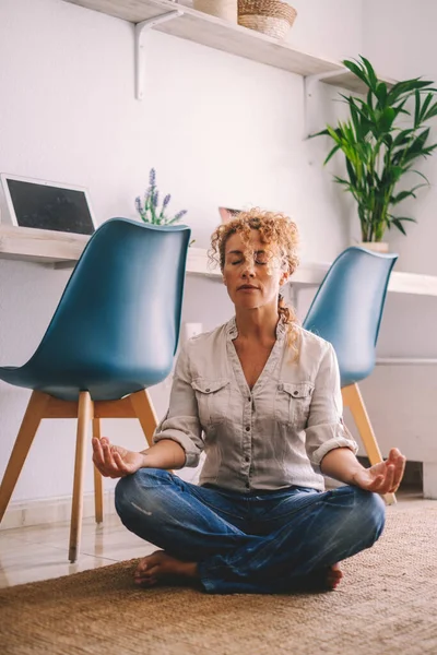 Kadın Evde Günlük Kıyafetleriyle Oturmuş Lotus Yoga Pozisyonunda Meditasyon Yapıyor — Stok fotoğraf