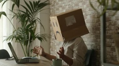 Kimlik ve şifre kurtarma sorunları internette bilgisayar ve web sayfalarıyla çalışıyor. İş yerindeki insanlar kafalarında karton üzgün kutuyla. Ofiste dizüstü bilgisayarı olan depresyonda bir işçi.