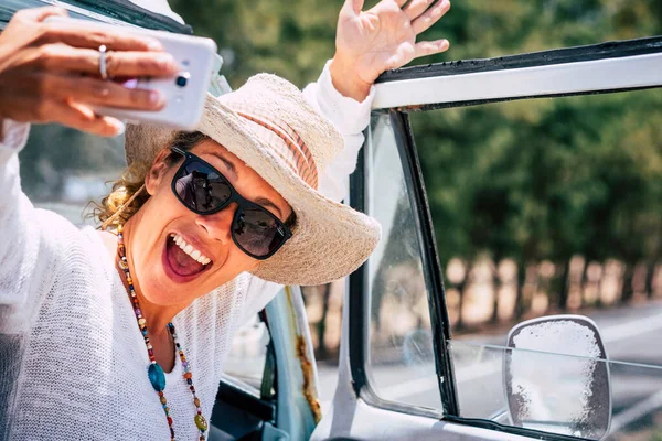 快乐而兴奋的年轻女性用手机自拍 女性在旅行时使用手机 道路和室外背景 在社交媒体上分享生活的人 — 图库照片