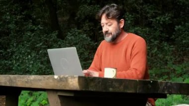  Dışarıda dizüstü bilgisayarla çalışan bir adam. Kablosuz ve gezinen internet kablosuz bağlantısı ve insanlar teknolojiyi online iş ve akıllı çalışma için kullanıyorlar