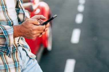 El manifatura iletisinde telefon tutarak veya mobil uygulamaları kullanarak, sosyal medya uygulamaları yeni siyah smartphone cep telefonu ile kontrol, oyun oyun cep telefonu, erkek müşteri ve gadget yakın bakış üzerinde çalışıyor adam