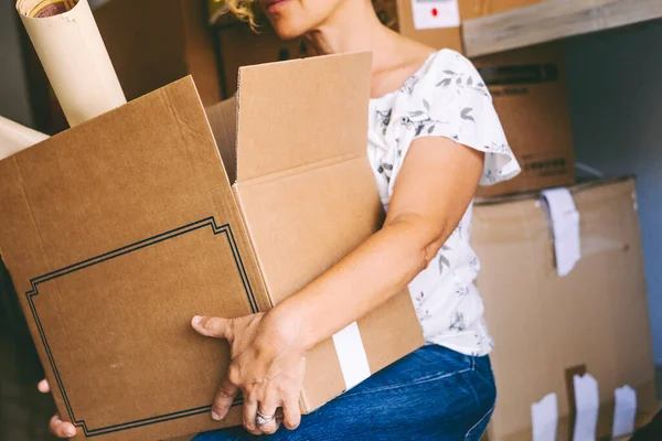 Unrecognizable woman holding big carton boxes packages moving to a new home and life. Mortgage and loan concept people. Young female moving and changing house with packages. Delivery shipment activity