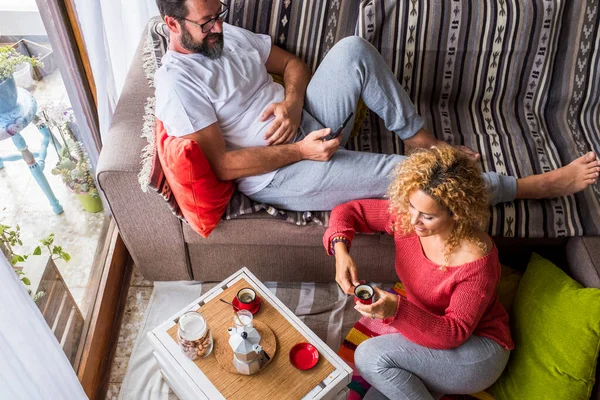Above view of adult couple at home having breakfast leisure time together. Concept of real life for middle age man and woman. Apartment top view with people enjoying lifestyle