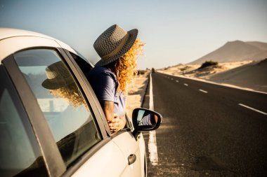 Turistler teneffüste arabanın penceresinin önünde güneşlenmeyi severler. Yolun kenarına park etmiş araçlar ve manzaraya hayran olan kadınlar. Seyahat ve yaz tatili kavramı