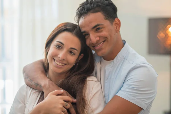 Concept of young interracial couple in love and relationship. Boy hug and protect girlfriend at home. Life and future together, man and woman. New apartment happiness satisfaction portrait. Smile