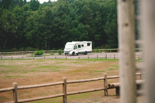 Modern camper motor home parked in the free nature alone. People enjoying travel and drive holiday vacation. Alternative off grid home and living lifestyle people. Van life and forest background