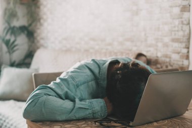 Overworked freelance sleep on the laptop keyboard. One man sleeping on computer after work. Concept of stress and home high bills. Desperation and job business. People tired sleep on a notebook