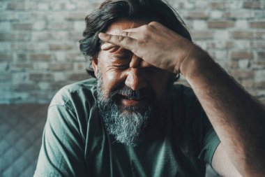 Headache and migraine unhealthy concept. Man touching his front and do painful expression for problems and ache. Stressed and worried people at home indoor. Portrait of male with flu symptom influenza
