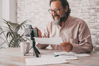 One man record content using a mobile phone to upload on video channel web page. Content creator people speaking and talking with cellular. Modern worker and internet business job activity. Video call