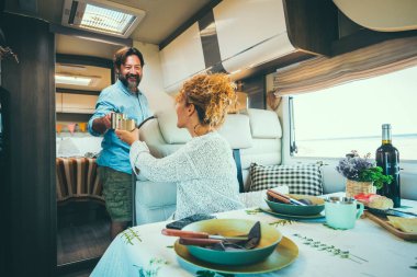 Couple living off grid inside a modern luxury camper van and enjoy