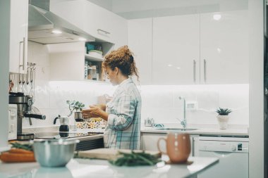 Kadın mutfakta tek başına yemek pişiriyor. Bağımsız kadınlar için gerçek bekar yaşam tarzı. Ev hanımı aile için öğle yemeği hazırlıyor. Esrar kullanan bir kadının manzarası ve ev yaşamını hazırlamak.