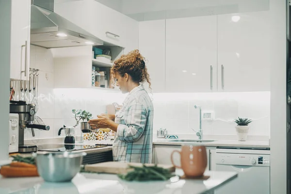 一个女人独自在家厨房做饭 独立女性真正的单一生活方式 家庭主妇为家人准备午餐 女士用锅子做饭室内生活的景象 — 图库照片
