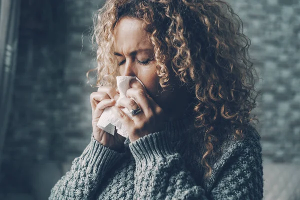女性在家中为感冒症状吹鼻涕的侧视图 降低室内温度以节省能源成本 使用纸巾感染病毒的女性患者 — 图库照片
