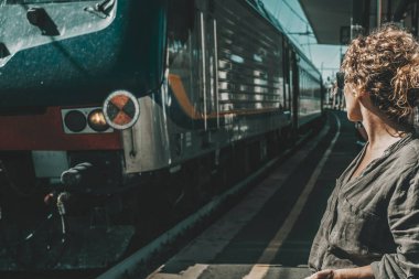 Bir turist kadın tren istasyonunda bekliyor. İş seyahati ya da tatil kavramı. Demiryolu gezisinde boş zaman aktivitesi. Kayıp ya da gecikmiş, nakil problemleri iptal edildi. Yalnız seyahat eden insanlar.