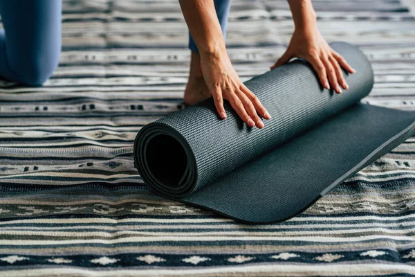 在家庭进行了完整的健康生活方式锻炼后 女性的手在家中合拢瑜伽垫 健康与体育概念在室内健身休闲活动中的应用 活跃的妇女 — 图库照片
