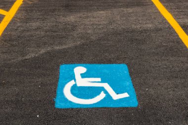 Tekerlekli sandalye kullanıcıları için özel park yeri, bu durumdaki kişiyi sembolize eden yolda mavi ve beyaz boya.