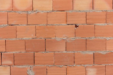 Duvarcılık için kullanılan kil tuğla yığını. Görüntü zaten inşa edilmiş duvarı gösteriyor..