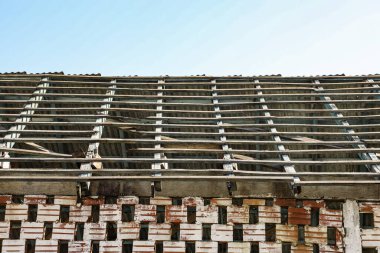 Duvarı kil renginde açık tuğlalarla kaplı ve zamanla solmuş beyaz bir boya var. Yukarısı içi boş tuğla ve çatının olduğu ve terk edildiği yer gibi görünüyor..