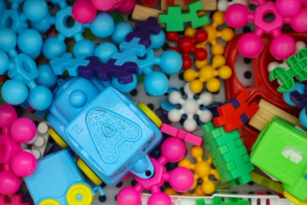 White plastic box with various toys in different colors and in different shapes.