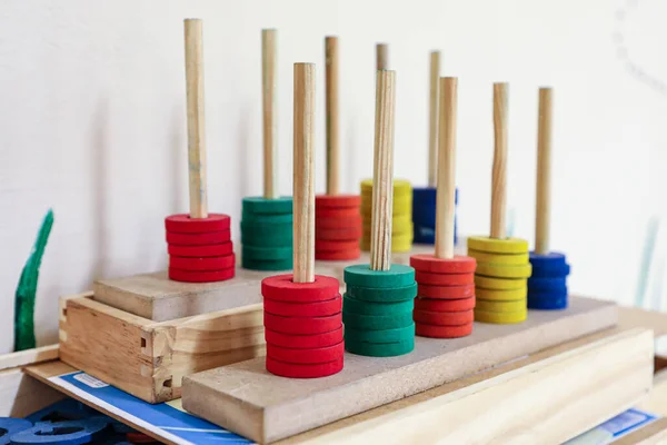 Soroban abacus in wood and colored, with the colors red, green, orange, yellow and blue, used for children\'s learning. Formed by a rectangular frame with parallel rods, where each corresponds to a multiple of ten.