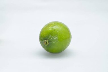 A whole lemon lying on a white background, even lying down, you can see the upper part of the fruit, which is apparently lying down
